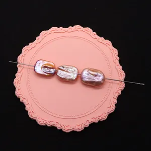 Tre perle d'acqua dolce barocche viola con riflessi metallici su vassoio rosa per DIY