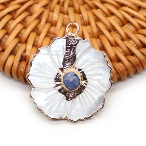 Détail macro du pendentif pétale en nacre blanche avec pierre bleue et bord doré
