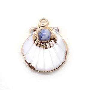 Detailed view of scallop shell pendant with blue natural stone and gold metal frame