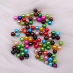 Colorful polished round DIY pearl beads in diverse vibrant colors on white plush background