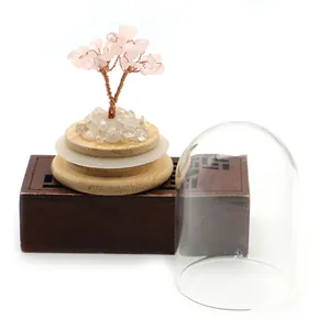 Detail of pink crystal money tree with wire branches on wooden base and glass dome