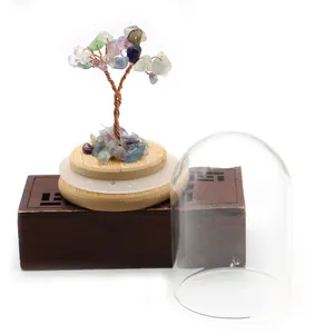 Detail of colorful crystal money tree with copper wire trunk in glass dome and wooden base