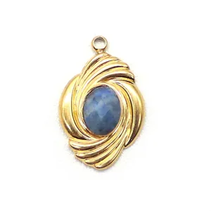 Macro detail of a gold-plated spiral pendant with an oval blue gemstone inlay