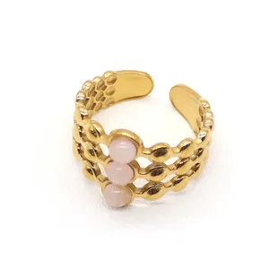 Detail of adjustable gold ring with three rows of beads and inlaid pink stones