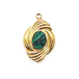 Macro shot of gold geometric pendant with spiral texture and oval green malachite stone