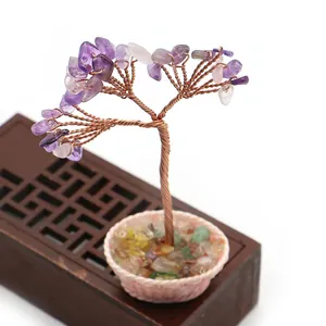 Detalle de árbol de amatista hecho a mano con hilos de cobre sobre base tejida rosa
