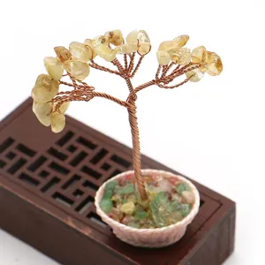 Detalle del árbol de cristal citrino con ramas de cobre en una maceta blanca de cerámica