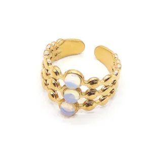 Macro view of triple-layered gold open ring featuring three luminous opal stones