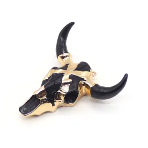 Macro view of bull skull pendant with contrasting black finish and gold plated horns