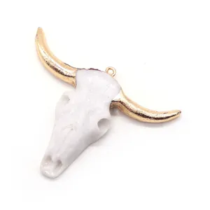 Macro view of white resin bull skull pendant with electroplated golden horns for DIY jewelry