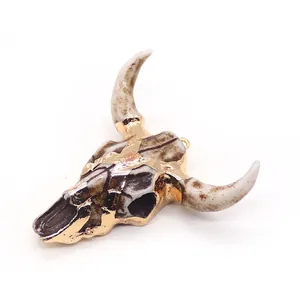 Detailed view of resin bull skull pendant with gold plating and natural stone texture