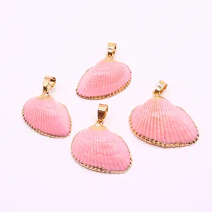Detailed view of four pink dyed natural shell charms with gold plated edges and jump rings