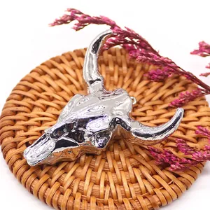 Macro view of a silver bull skull pendant with detailed bone texture and hanging ring
