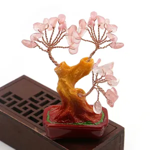 Detalle de hojas de piedras de cristal rosa y ramas envueltas en alambre de este árbol