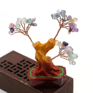 Detalle de árbol de cristales naturales con ramas de cobre y base de resina roja