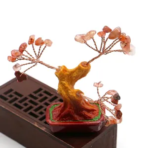 Detalle de árbol de cristal con ramas de hilo de cobre y base de piedra de resina