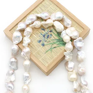 Fil de perles d'eau douce baroques naturelles au lustre intense sur plateau bambou