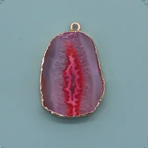 Détail macro d'un pendentif en agate rose naturelle avec bordure dorée galvanisée