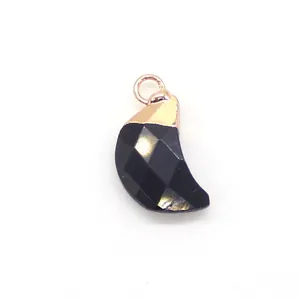 Vue macro d'un pendentif lune facetté noir avec bélière dorée pour la création de bijoux DIY