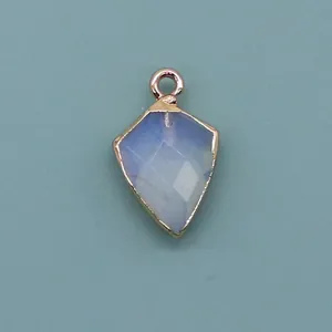 Macro detail of kite-shaped natural stone pendant with faceted edge and rose gold plated rim