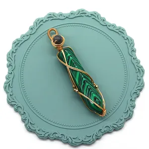 Détail macro du pendentif malachite hexagonal avec design fait main en fil doré