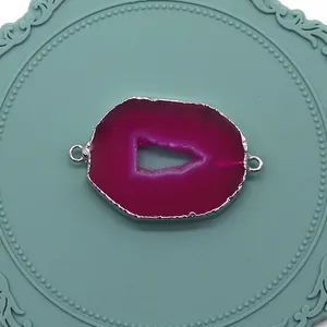 Dettaglio macro del connettore in agata naturale fucsia con bordi in metallo argentato