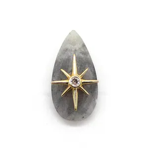 Dettaglio del pendente in pietra grigia sfaccettata con stella dorata e intarsio in zircone