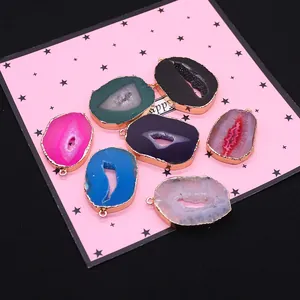 Lot de sept pendentifs en tranches d'agate naturelle avec bordure dorée en couleurs variées