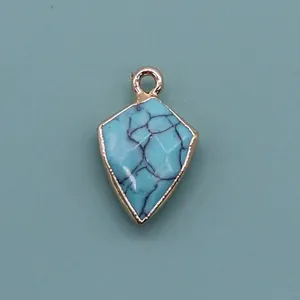 Macro detail of faceted blue stone pendant with gold edge and shield shape design