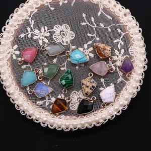 Gold-rimmed natural stone shield pendants in various colors on vintage lace display