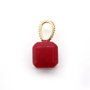 Macro detail of square cut red gemstone pendant with vintage gold beaded bail accent