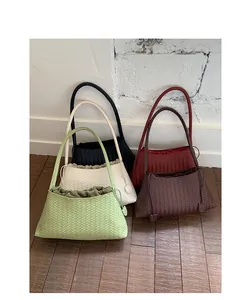 Vista dettagliata di borse tote intrecciate in cinque colori con trama raffinata