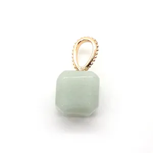 Macro detail of square green stone pendant with rose gold milgrain textured metal ring