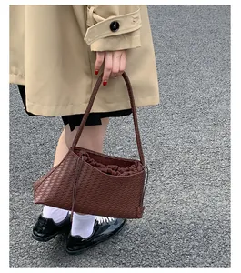 Dettaglio della borsa sottobraccio in pelle intrecciata marrone scuro con fodera a coulisse