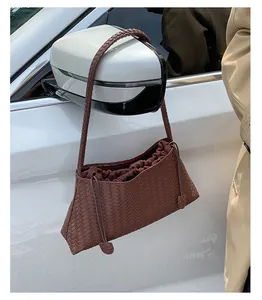 Dettaglio della borsa a spalla in pelle intrecciata marrone con texture intrecciata laterale