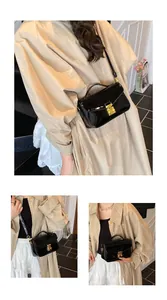 Detail of glossy black patent leather handbag with premium gold twist lock closure