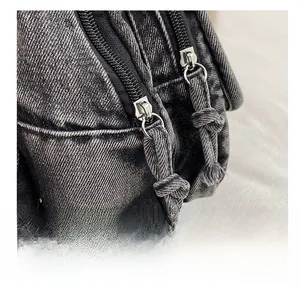 Detail of premium denim backpack showing dual zippers and sturdy metal hardware pullers