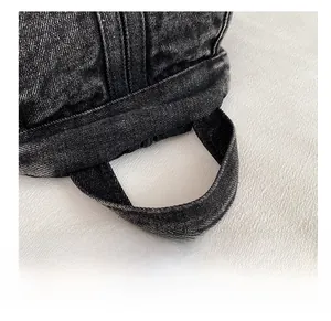 Close-up of the durable denim handle with reinforced stitching on a vintage backpack