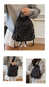 Close-up of black washed denim mini backpack showing crossbody and handheld styling ways