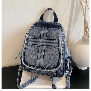 Detail of acid wash denim backpack showing cross-stitching and metal zipper textures