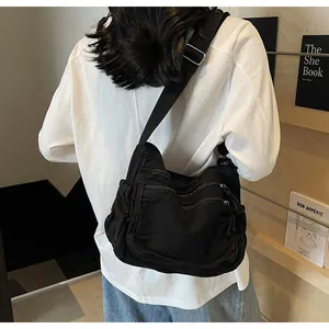 Detail view of black washed canvas crossbody bag with multi-zipper pockets and strap