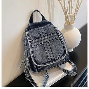 Close-up of acid wash denim backpack with front flap pocket on white decorative props