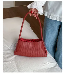Dettaglio della borsa a tracolla intrecciata rosso scuro con fodera interna a coulisse