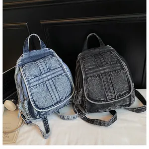 Detail view of vintage denim backpacks in light blue and charcoal black with flap closure