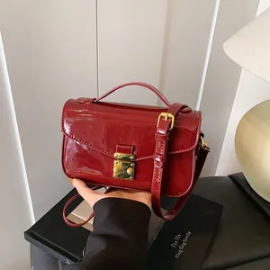 Elegant wine red patent leather handbag with gold clasp and top handle for women