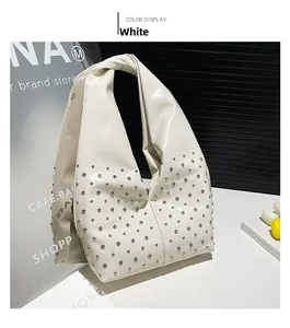 Détail du sac cabas blanc clouté en cuir PU brillant avec des rivets argentés élégants