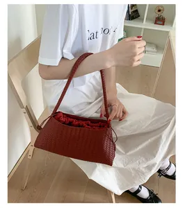 Dettaglio della trama intrecciata rosso scuro e fodera con coulisse della borsa
