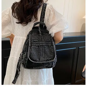 Detailed back view of a retro black denim backpack on a model wearing a lace dress