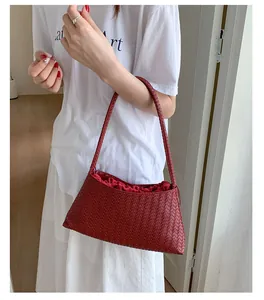 Dettaglio borsa a tracolla intrecciata rossa con fodera a coulisse e trama in pelle