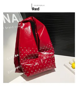Détail du sac cabas en cuir verni rouge avec des décorations de rivets brillants
